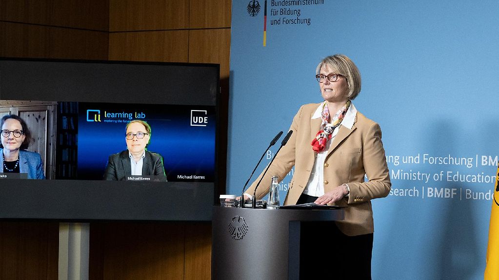Bundesministerin Anja Karliczek steht an einem Rednerpult im Ministerium.