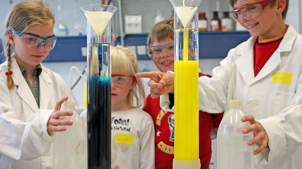 Drei Kinder nehmen im Rahmen der Kinderuni an der Universität Leipzig Experimente im Labor der Fakultät für Chemie und Mineralogie vor.