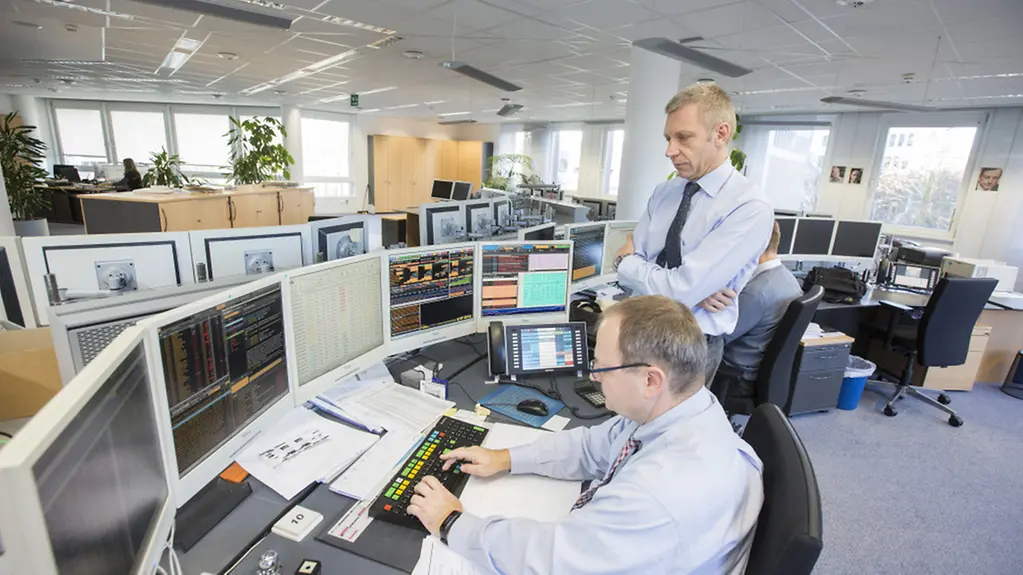 Thomas Weinberg mit einem Kollegen an einem Arbeitsplatz in der Bundesrepublik Deutschland Finanzagentur GmbH.