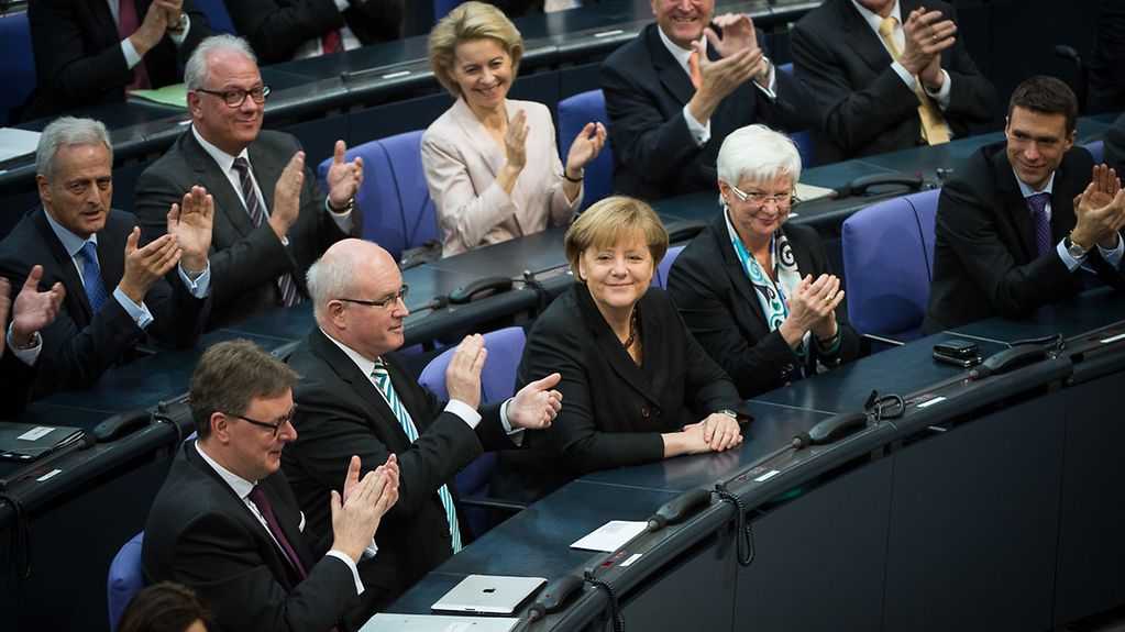 Members of the German Bundestag applaud Chancellor Angela Merkel.
