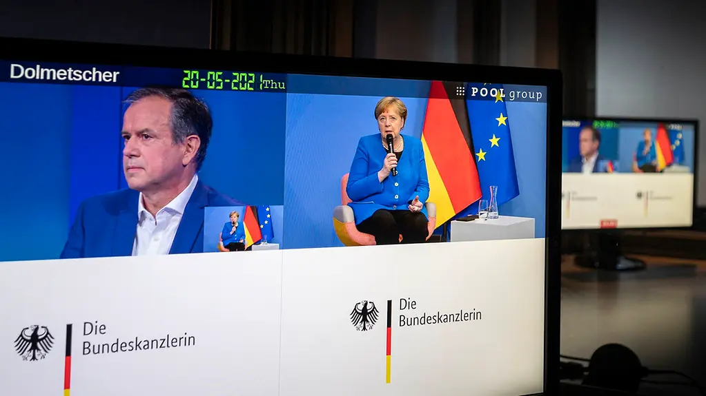 La chancelière fédérale Angela Merkel et Andreas Cichowicz, rédacteur en chef de la Norddeutscher Rundfunk, sur deux écrans pendant leur visioconférence