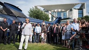 Bundeskanzlerin Angela Merkel beim traditionellen Rundgang am Tag der offenen Tür im Bundeskanzleramt mit Publikum neben einem Hubschrauber der Bundespolizei.