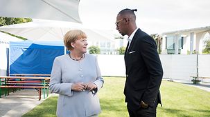 Bundeskanzlerin Angela Merkel im Gespräch mit Jerome Boateng.