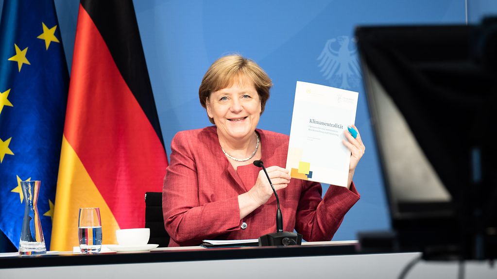 At the annual meeting of the German Council for Sustainable Development Chancellor Angela Merkel holds up the expert report on climate neutrality.