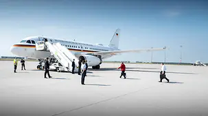 Bundeskanzlerin Angela Merkel geht, gefolgt von ihrem Ehemann Joachim Sauer, zum Flugzeug.
