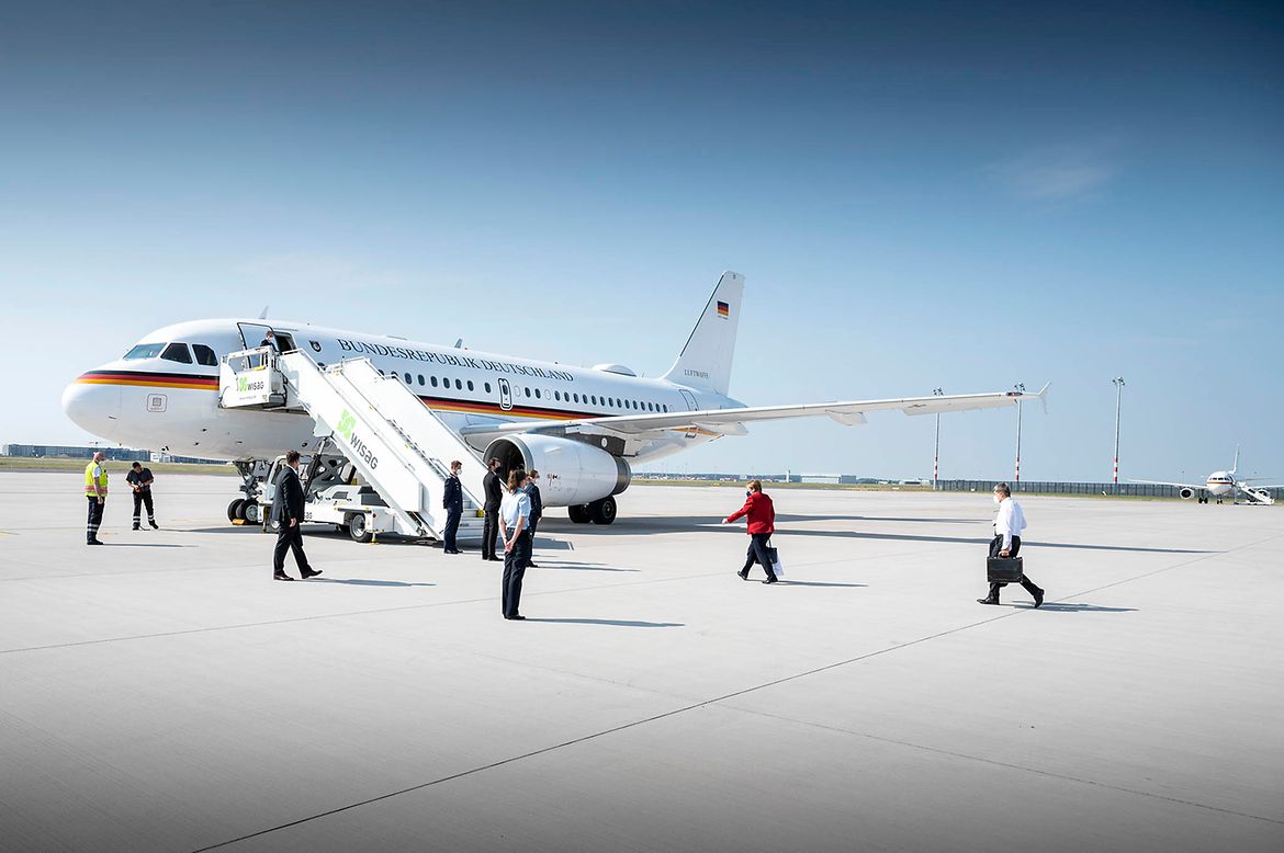 Bundeskanzlerin Angela Merkel geht, gefolgt von ihrem Ehemann Joachim Sauer, zum Flugzeug.