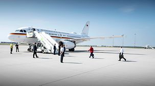 La chancelière fédérale Angela Merkel se rend à son avion, suivie de son mari Joachim Sauer
