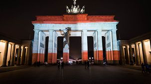 Das Brandenburger Tor in Berlin leuchtet in den "Berlin-Farben".