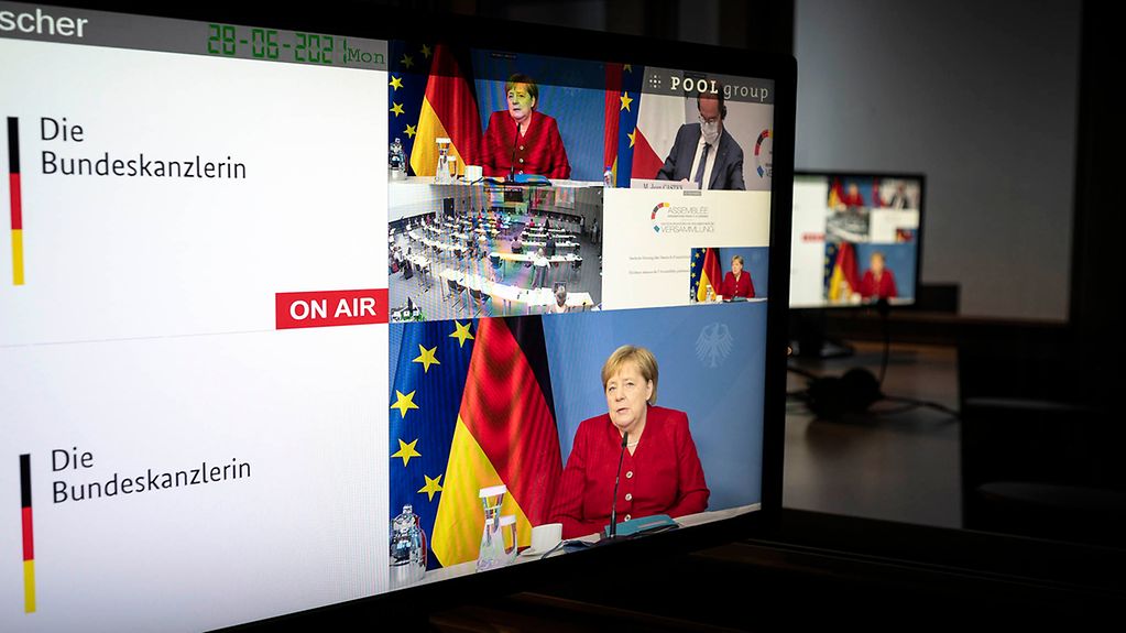 Monitore zeigen Bundeskanzlerin Merkel bei ihrer Teilnahme an der Deutsch-Französischen Parlamentarischen Versammlung.