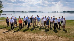 Gruppenfoto der Zukunftskommission Landwirtschaft vor einem See.