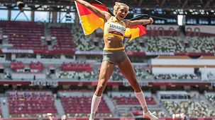 Malaika Mihambo jubelt mit Deutschlandfahne über ihren Olympiasieg.