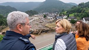 Bundeslandwirtschaftsministerin Julia Klöckner besucht das Katastrophengebiet an der Ahr und schaut sich von einer Brücke den Ort Altenburg an. 