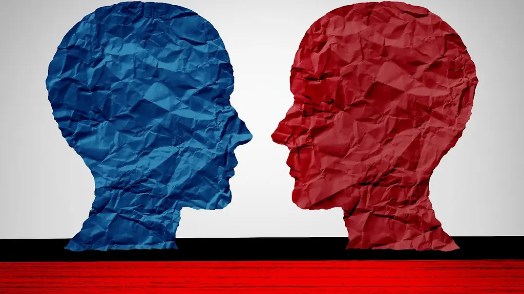 Photo with symbols of far-right extremism: one red and one blue head, made of paper, face each other.