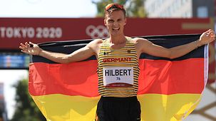 Jonathan Hilbert mit Deutschland-Fahne nach seinem Silbermedaillen-Gewinn über 50km Gehen.