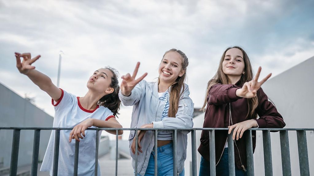 Drei Mädchen posieren mit Visctory-Zeichen