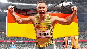 Felix Streng freut sich mit deutscher Fahne über seine Goldmedaille.