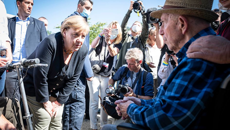 Bundeskanzlerin Angela Merkel im Gespräch mit einem Senioren.