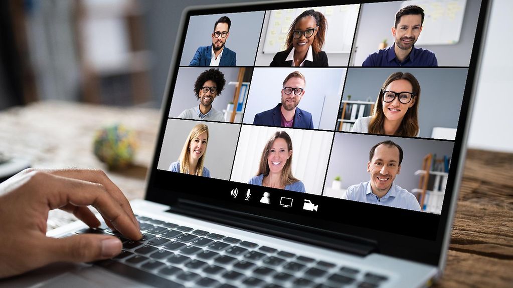Menschen in einer Videokonferenz, abgebildet auf einem Laptop-Monitor
