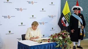 Kanzlerin Merkel trägt sich in das Goldene Buch der Stadt Halle (Saale) ein.
