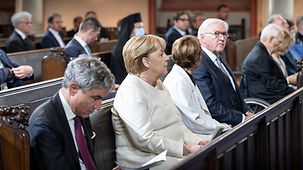 La chancelière fédérale Angela Merkel est assise sur un banc de l’église Saint-Paul, en compagnie du président de la Cour constitutionnelle fédérale Stephan Harbarth et du président fédéral Frank-Walter Steinmeier