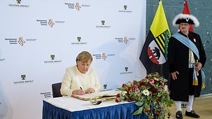 La chancelière fédérale Angela Merkel signe le Livre d’or de la ville de Halle-sur-Saale