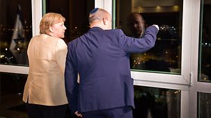 Bundeskanzlerin Angela Merkel und Naftali Bennett, Israels Premierminister, schauen aus dem Fenster.