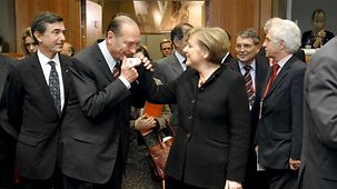 Frankreichs Präsident Chirac küsst Bundeskanzlerin Merkel die Hand.