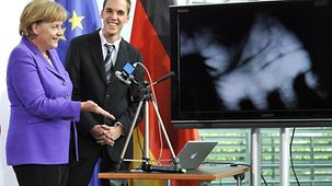 Bundeskanzlerin Angela Merkel testet eine Kamera mit der Venen erkannt werden, entwicklelt vom Gewinner des Sonderpreises, Steffen Strobel