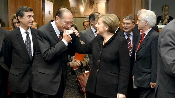 Frankreichs Präsident Chirac küsst Bundeskanzlerin Merkel die Hand.