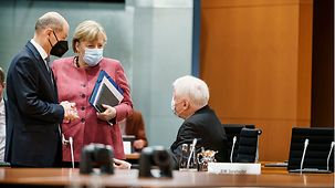 Federal Chancellor Angela Merkel in conversation with Horst Seehofer, Federal Minister of the Interior, Building and Community, and Olaf Scholz, Federal Minister of Finance.