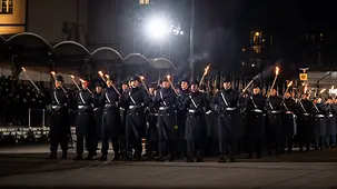 Bundeswehrsoldaten mit Fackeln marschieren bei einem Großen Zapfenstreich.