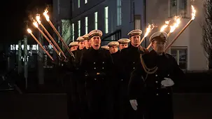 Bundeswehrsoldaten mit Fackeln marschieren bei einem Großen Zapfenstreich.