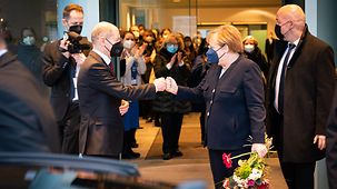 Bundeskanzlerin Angela Merkel verabschiedet sich von Bundeskanzler Olaf Scholz.