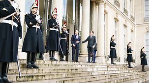 Bundeskanzler Olaf Scholz wird von Emmanuel Macron, Frankreichs Präsident, begrüßt.
