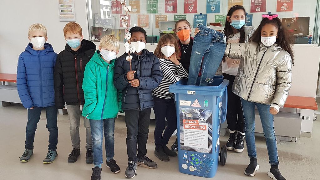 Kinder einer Grundschule mit einer Recycling-Tonne