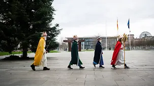 Sternsinger gehen nacheinander im Bundeskanzleramt.