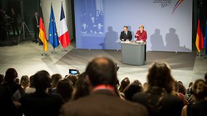 Merkel und Hollande am Rednerpult.