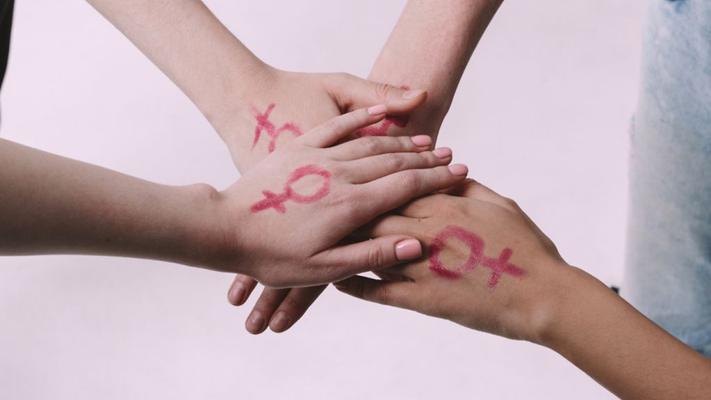 Vier Frauenhände liegen übereinander