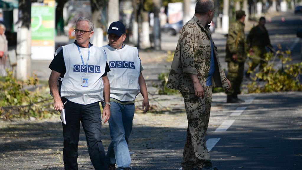 Members of the OSCE examine the scene of a shelling in the town of Donetsk, eastern Ukraine. (AP Photo/Mstislav Chernov)