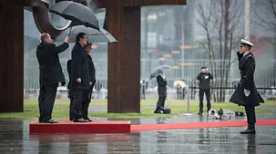 An officer of the guard of honour salutes the heads of government.
