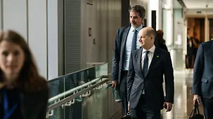 Bundeskanzler Olaf Scholz geht vor Steffen Hebestreit, Sprecher der Bundesregierung.