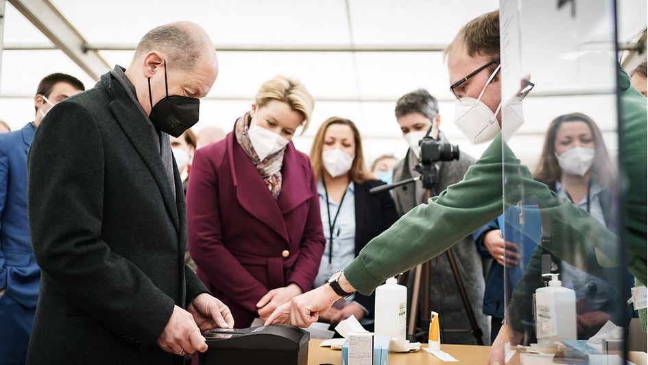 Bundeskanzler Olaf Scholz testet im Ankunftszentrum in Berlin-Tegel die Registrierung mit Fingerabdruck.
