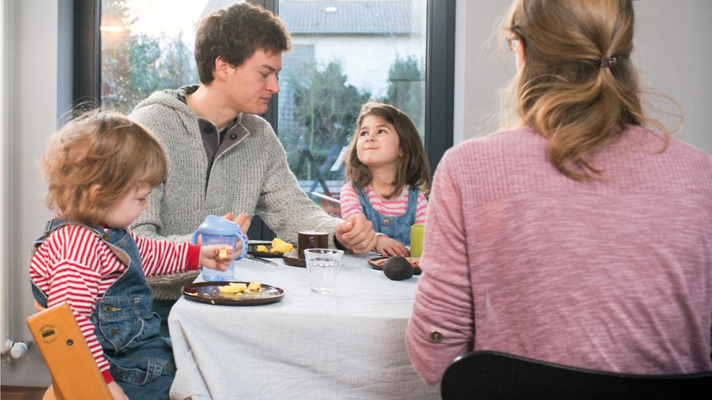 Une jeune famille avec deux enfants au petit-déjeuner