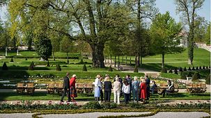 Die Kabinettsmitglieder stehen im Garten von Schloss Meseberg zusammen.