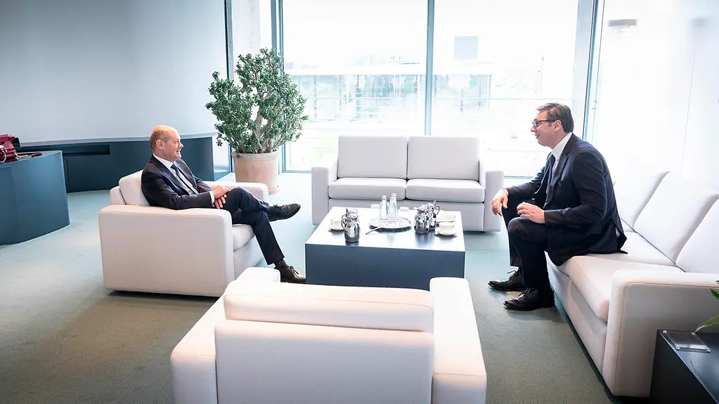Das Bild zeigt Kanzler Scholz und Präsident Vučić. Sie sitzen auf weißen Sesseln im Bundeskanzleramt.
