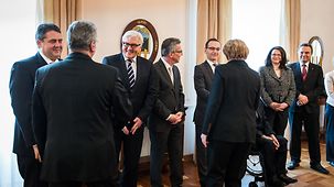 Bundeskanzlerin Angela Merkel und Bundespräsident Joachim Gauck begrüßen die wartenden Minister.