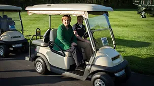 Bundeskanzlerin Merkel in einem Golf Car.