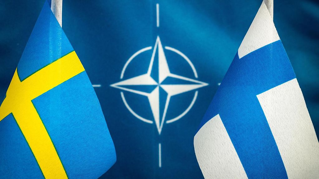 Die Fahnen von Schweden und Finnland, in der Mitte das Nato-Logo.
