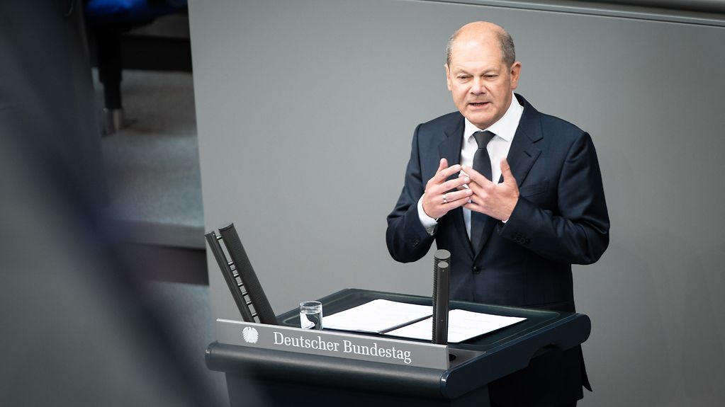 Kanzler Olaf Scholz spricht am Rednerpult des Bundestages.