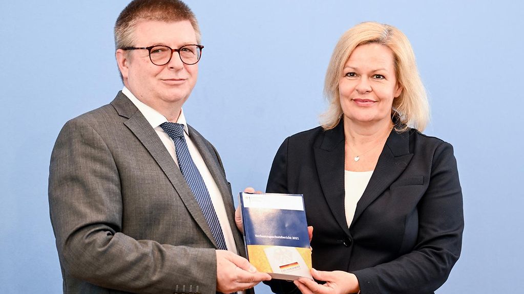 Bundesinnenministerin Faeser und Verfassungsschutzpräsident Haldenwang halten zusammen den Verfassungsschutzbericht 2021.